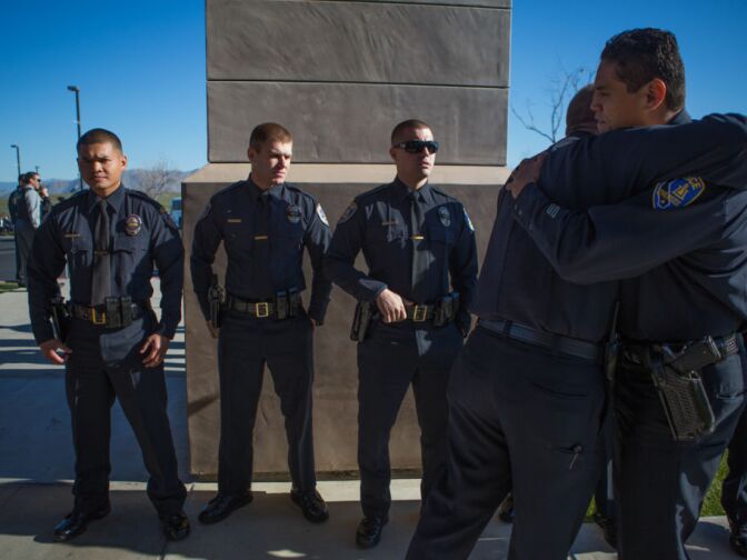Riverside Police Officers console each other outside of Grove Community Church before Michael Crain's funeral on February 13th, 2013.