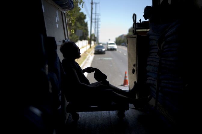 Moving company employee Oscar Vaquez, 29, takes off his hat while resting in a freight container Tuesday, Aug. 29, 2017, in Los Angeles. California energy authorities urged voluntary conservation of electricity Tuesday as a wave of triple-digit heat strained the state's power grid. (AP Photo/Jae C. Hong)