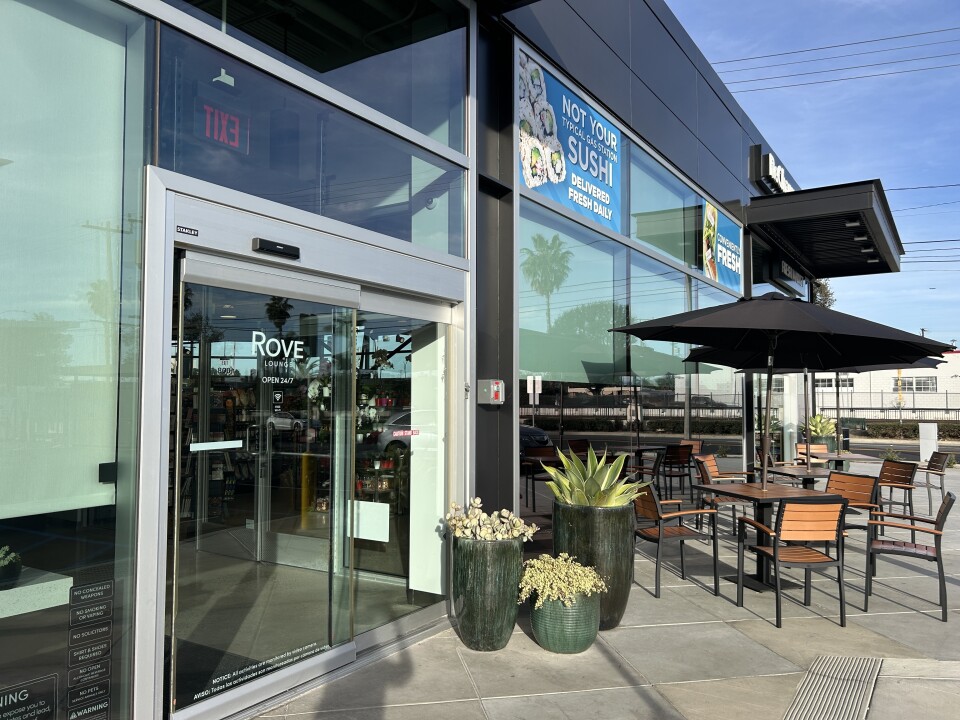 Several tables with chairs outside of a building storefront.