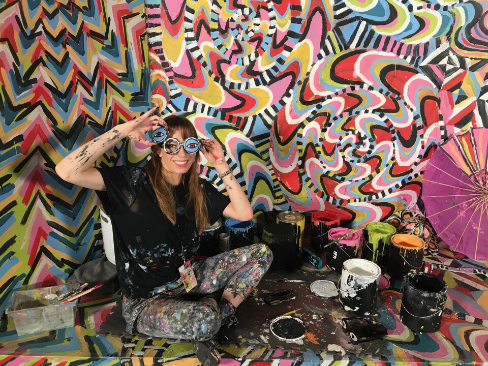 Artist Alexa Meade shows off her prop glasses in her room called Become the Masterpiece. Visitors put on clothes and costume props to become part of a pyschedlic backdrop. Photo credit: Adriana Cargill