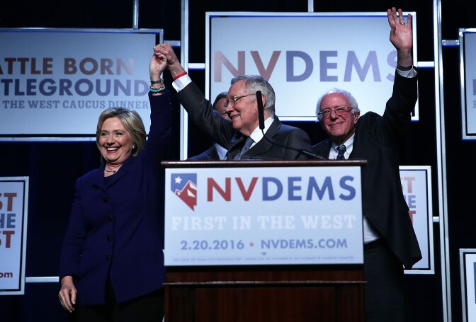 LAS VEGAS, NV - JANUARY 06:  Democratic Presidential candidates Hillary Clinton (L) and Sen. Bernie Sanders (I-VT) (R) on stage with Senate Minority Leader Harry Reid (D-NV) (2nd L) prior to the Battle Born/Battleground First in the West Caucus Dinner at the MGM Grand January 6, 2016 in Las Vegas, Nevada. The three candidates continue to campaign prior to the Nevada Democratic caucus, which will take place on February 20, 2016.  (Photo by Alex Wong/Getty Images)