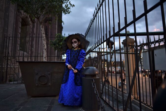 A girl dressed as Catrina is seen during a protest against femicides in Mexico City on November 1, 2016.