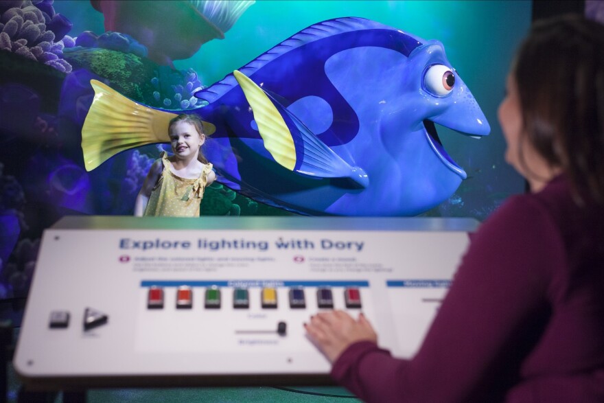 Visitors adjust the lighting for their photo with Dory.