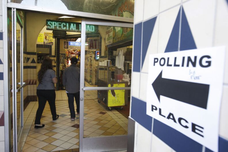 A sign points the way to a polling place inside El Mercado de Los Angeles, a Mexico-style marketplace in the East L.A. area during the U.S. presidential election on November 6, 2012.