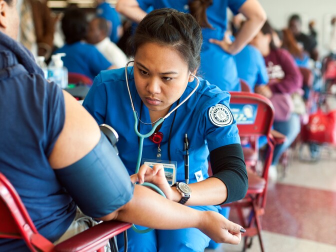 Nursing students check blood pressure during Care Harbor's annual Los Angeles medical clinic at the Los Angeles Memorial Sports Arena on Thursday, Oct. 31.