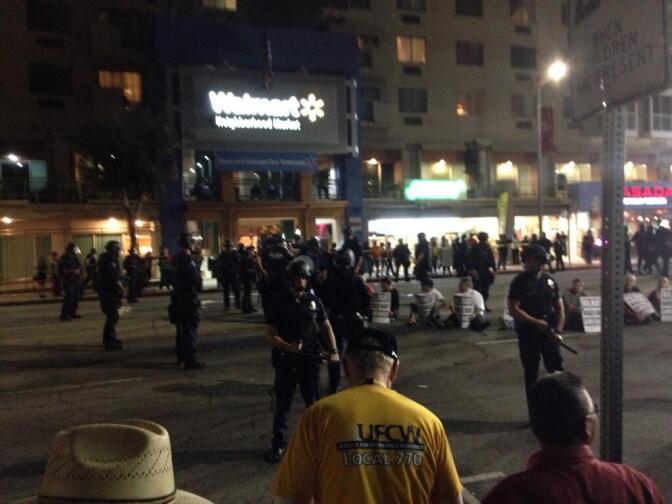 Street sitters drawing cheers, making traffic, at a protest outside new Walmart in Chinatown.