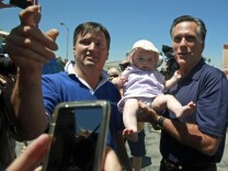 Republican 2012 presidential hopeful, former Gov. Mitt Romney of Massachusetts, poses with Stephen Winnick and his 7-month-old daughter Sarah before a news conference at a mostly-empty shopping center in the North Hollywood area of Los Angeles on July 20, 2011.
