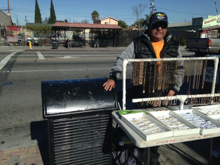 Armando Ventura sells gold-plated costume jewelry at the corner of Florence and Graham avenues in unincorporated Los Angeles County. He's one of several vendors cited recently. The city of Los Angeles is considering decriminalizing street vending, but the county is not.