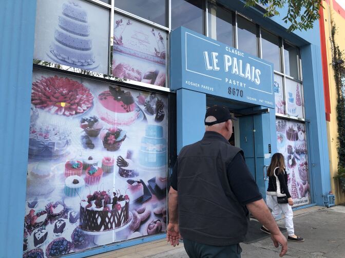 A storefront has images of pastries on top of a blue facade. The sign reads: Classic Le Palais Pares, Kosher pareve