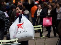 The Commerce Department Friday said Americans cut back on spending in April after their income failed to grow, a sign economic growth may be slowing. The department said the decline in consumer spending is the first since May 2012. (A shopper talks on the phone after leaving Macy's department store in in New York City. Photo by Andrew Burton/Getty Images)