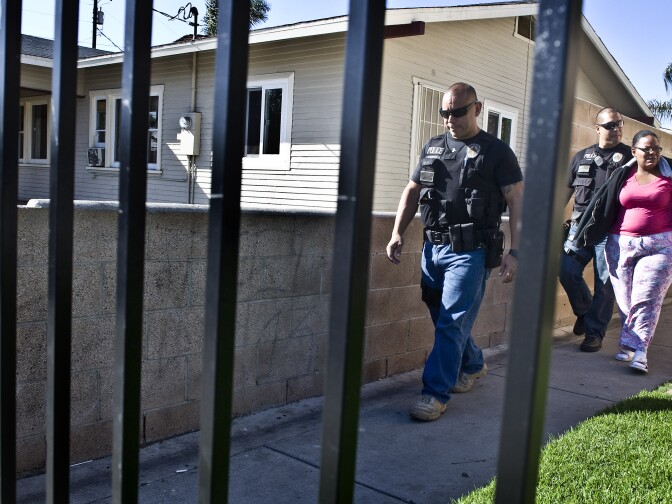Buena Park police officers Luis Garcia, left, and James Woo, escort Cheree People, 33, to their patrol car, handcuffed and under arrest after ignoring several attempts by law enforcement, school officials and members of the Distrtict Attorneys office to help her get her elementary school child's high truancy rate reduced. The child had accumulated 20 unexcused absences as of January. Peoples was arrested at her home and charged with one misdemeanor count of contributing to the delinquency of a minor and one misdemeanor count of failure to reasonably supervise or encourage school attendance. If convicted, parents faces a sentence ranging from probation up to one year in jail and $2,500 in fines.