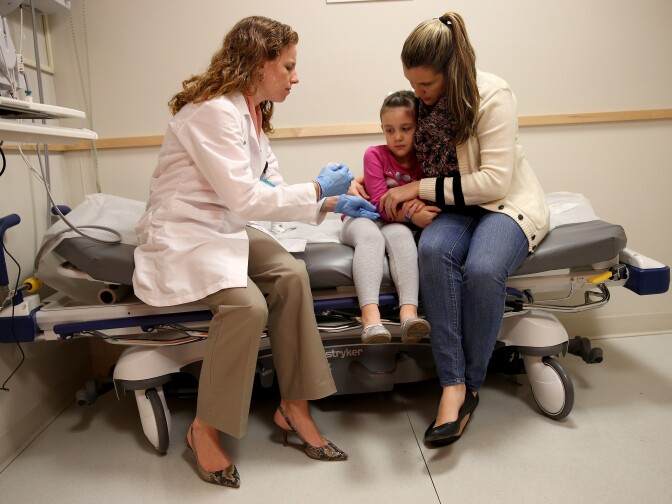 Miami Children's Hospital pediatrician Dr. Amanda Porro, M.D prepares to administer a measles vaccination to Sophie Barquin,4, as her mother Gabrielle Barquin holds her during a visit to the Miami Children's Hospital on January 28, 2015 in Miami, Florida. A recent outbreak of measles has some doctors encouraging vaccination as the best way to prevent measles and its spread.  
