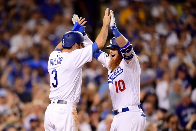 Justin Turner of the Los Angeles Dodgers celebrates with Chris Taylor after hitting a two-run home run during the sixth inning against the Houston Astros in game one of the 2017 World Series at Dodger Stadium on Oct. 24, 2017.