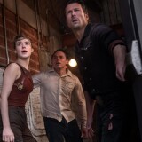 three people stand in an open doorway