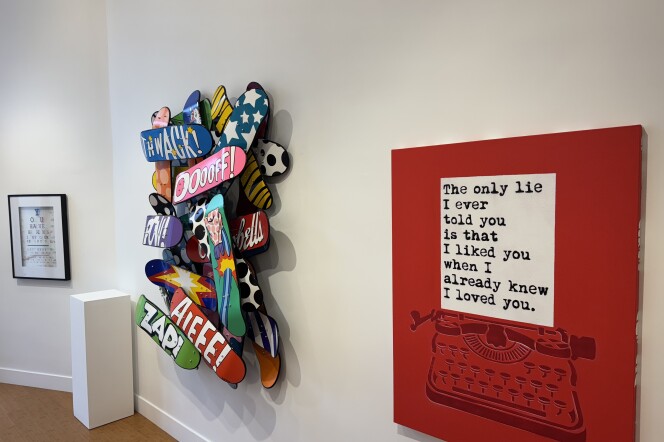 A wall with artworks like a sculpture and a painting hanging on it.