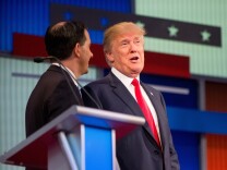 Republican presidential candidates Donald Trump (right) and Wisconsin Gov. Scott Walker speak together during a commercial break at the first Republican presidential debate in Cleveland on Thursday. Trump's remarks about Fox News debate moderator Megyn Kelly have triggered a firestorm.