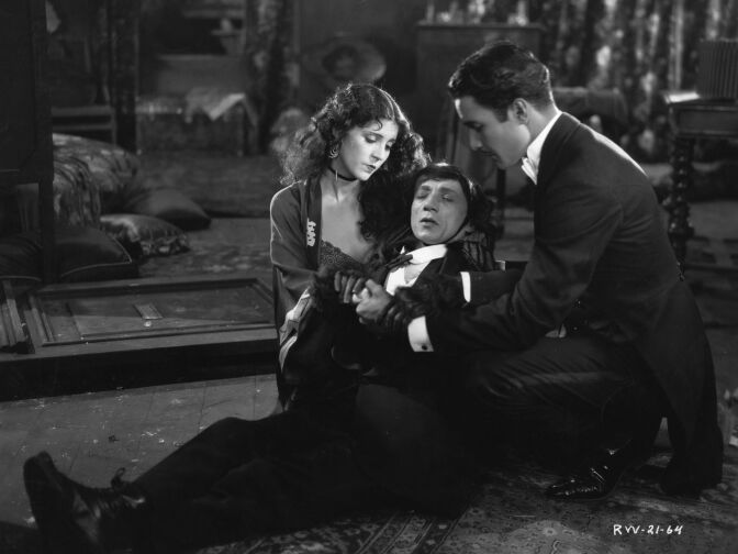 Actors Olive Borden and Don Alvarado support a stricken Jacques Lerner in a scene from the 1927 movie romance "The Monkey Talks."