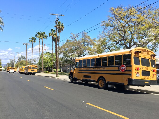 Los Angeles Unified School District buses wait to pick up students.