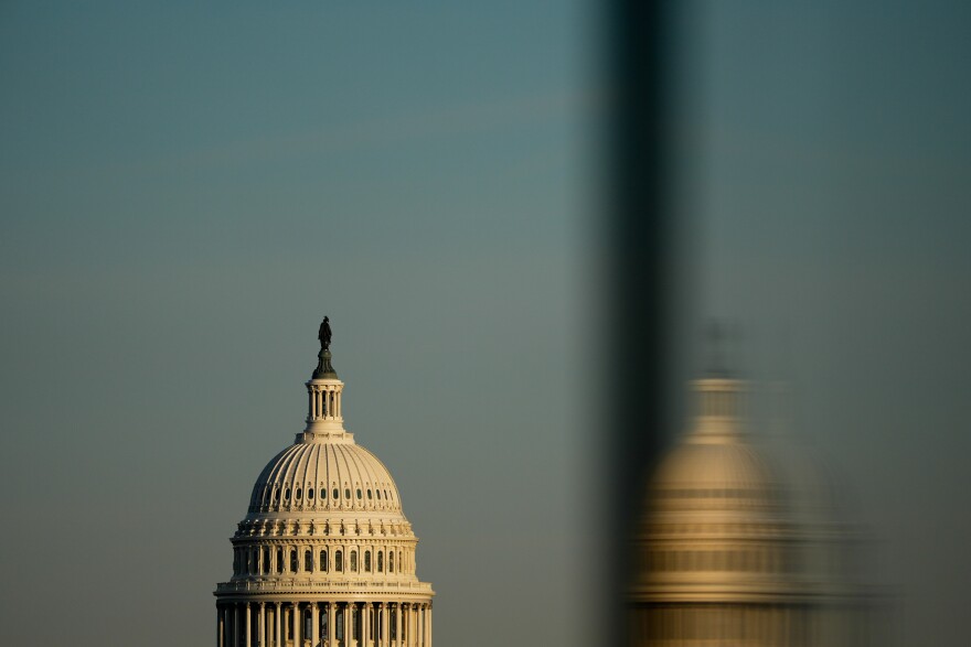 The top of the Capitol dome is visible, along with a reflection of the dome.