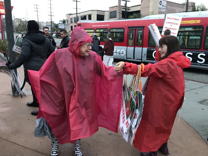 Teachers on strike at Taft High School in Woodland Hills pass out signs in the rain. 
