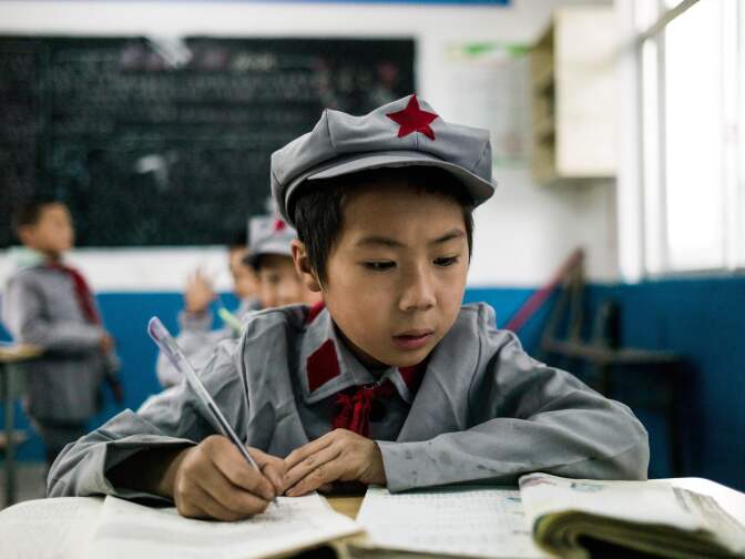 This photo taken on November 7, 2016 shows students studying in their classroom at the Yang Dezhi "Red Army" elementary school in Wenshui, Xishui country in Guizhou province. 
In 2008, Yang Dezhi was designated a "Red Army primary school" -- funded by China's "red nobility" of revolution-era Communist commanders and their families  one of many such institutions that have been established across the country. Such schools are an extreme example of the "patriotic education" which China's ruling Communist party promotes to boost its legitimacy -- but which critics condemn as little more than brainwashing. / AFP PHOTO / Fred DUFOUR        (Photo credit should read FRED DUFOUR/AFP/Getty Images)