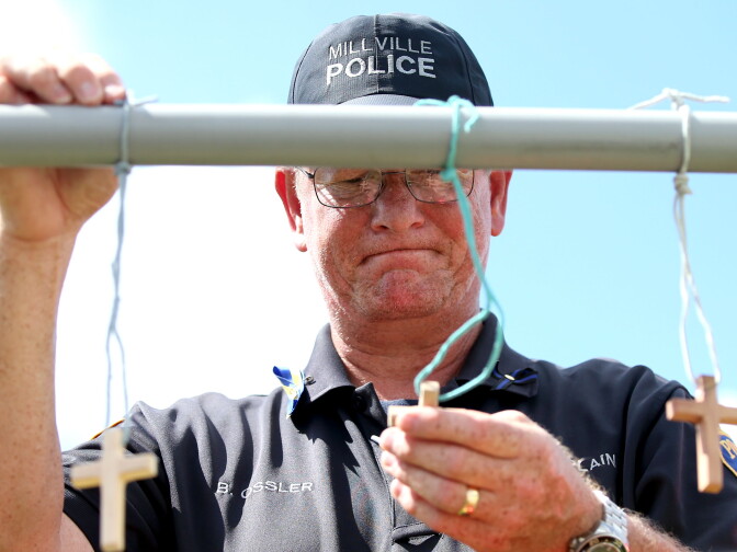 BATON ROUGE, LA - JULY 18:  Robert Ossler, Chaplain of the Police and Fire Department of Millville, NJ visits a memorial for the three police officers who were shot and killed in an ambush on July 18, 2016 in Baton Rouge, Louisiana. According to officials the gunman, Gavin Long, who fatally shot three law enforcement officers and wounded three others before being killed by the police was targeting officers.  (Photo by Sean Gardner/Getty Images)