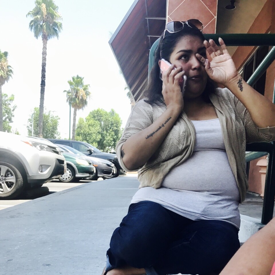 Helen Rivera, 35, sits on the floor in front of the Alfred Angelo store in West Covina, when she arrived to pick up her last bridesmaid dress and the store was unexpectedly closed.