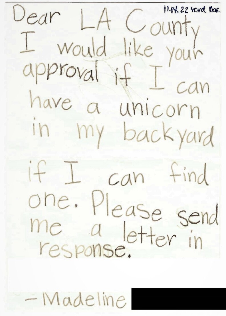 A letter written in pencil reads "Dear LA County, I would like your approval if I can have a unicorn in my backyard if I can find one. Please send me a letter in response. — Madeline." The last name has been redacted."