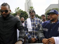 Rappers The Game, left, and Snoop Dogg, center, appear at a peaceful unification march outside of the graduation ceremony for the latest class of Los Angeles Police recruits in Los Angeles, Friday, July 8, 2016. Snoop shook hands with police officials and told reporters he hoped his presence would help reintroduce the black community to the Police Department and open a dialogue. The gathering comes a day after the shooting deaths of multiple police officers in Dallas on Thursday night. 