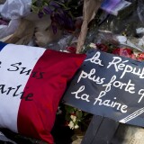 A cussion in the colours of the French flag reading "Je suis Charlie" (I am Charlie) and a placard reading "Republic stronger than hate" are layed  outside the headquarters of French satirical weekly Charlie Hebdo in Paris on February 7, 2015, in memory of victims one month after a deadly jihadist attack on the newspaper which killed 12 people, including celebrated cartoonists. Armed Islamist attacks against Charlie Hebdo, a policewoman and a Jewish kosher grocery in Paris from January 7-9 left a total of 17 people dead. The assault shocked France, and the slogan "Je suis Charlie", in solidarity with the victims, became a global rallying cry against extremism.    AFP PHOTO / JOEL SAGET        (Photo credit should read JOEL SAGET/AFP/Getty Images)