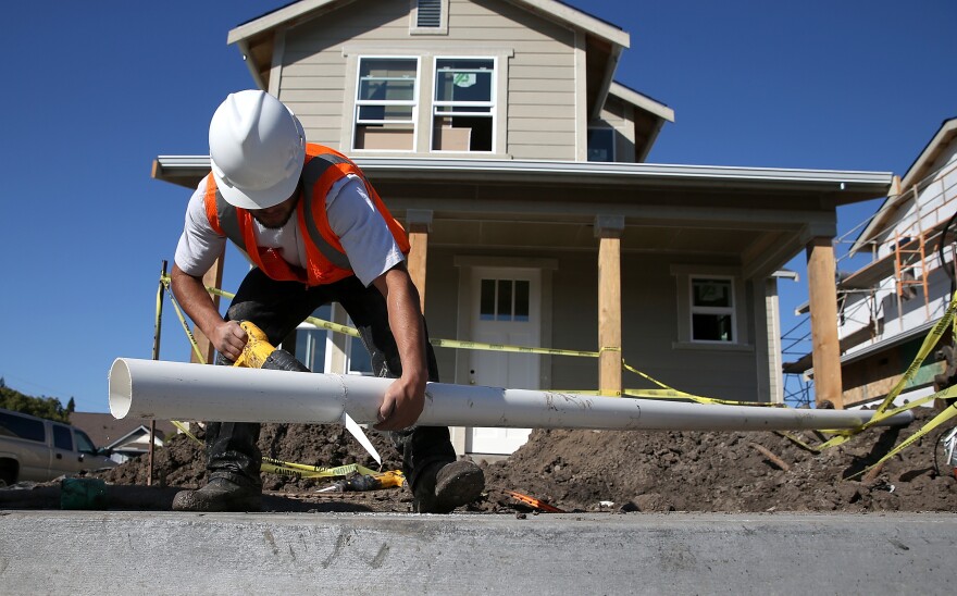 A worker cuts a piece of pipe as he builds a new home in January 2015 in Petaluma, Calif. Construction jobs had a strong 2015 in California.