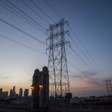 Downtown skyline is seen behind high tension towers from the 4th street bridge in Los Angeles, California on August 16, 2020. - California on August 14 ordered rolling power outages for the first time since 2001 as a statewide heat wave strained its electrical system. Pacific Gas & Electric, the states largest utility, tweeted that it would turn off power to about 200,000 to 250,000 customers in rotating outages for about an hour at a time. (Photo by Apu GOMES / AFP) (Photo by APU GOMES/AFP via Getty Images)