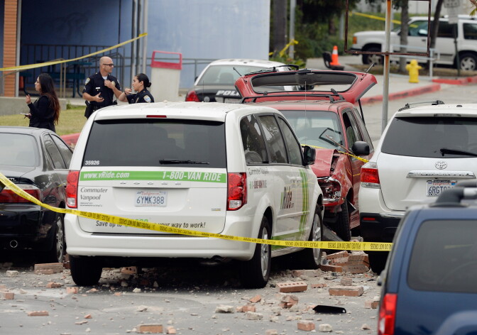 SANTA MONICA, CA - JUNE 07:  Law enforcement personal invstigate the shooting scene where an SUV crashed throught the wall of a parking lot and hit several cars across the street from the Santa Monica College weher a multiple shootings happened on campus June 7, 2013 in Santa Monica, California. According to reports, seven people are dead including the shooter and three people were injured.  (Photo by Kevork Djansezian/Getty Images)