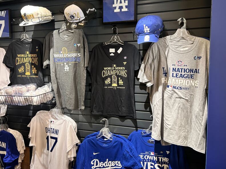 A wall with various t-shirts and hats hanging. Most of them read "World Series Champions."