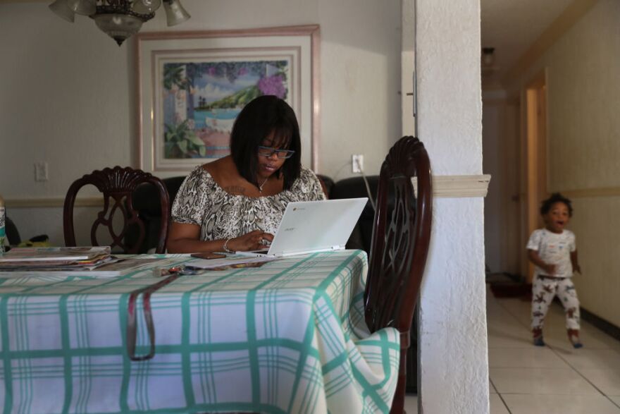 HOLLYWOOD, FLORIDA - MARCH 27: Jessie Morancy uses her computer to fill out the application for unemployment benefits after being laid off from her job at the Fort Lauderdale–Hollywood International Airport on March 27, 2020 in Hollywood, Florida. Mrs. Morancy said she lost her job as a wheel chair and customer service agent.  She is joining roughly 3.3 million Americans nationwide who are looking for financial help as restaurants, hotels, universities, stores and more shut down in an effort to slow the spread of COVID-19. (Photo by Joe Raedle/Getty Images)