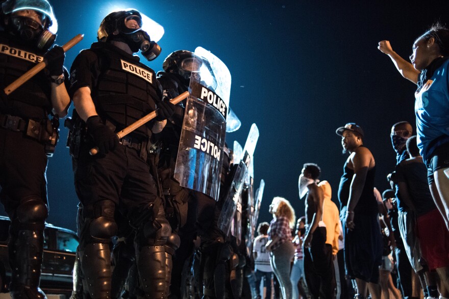 CHARLOTTE, NC - SEPTEMBER 21: Police officers face off with protesters on the I-85 (Interstate 85)during protests in the early hours of September 21, 2016 in Charlotte, North Carolina. The protests began last night, following the fatal shooting of 43-year-old Keith Lamont Scott by a police officer at an apartment complex near UNC Charlotte. (Photo by Sean Rayford/Getty Images)