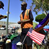 Homeless veteran Kendrick Bailey (C) has General Dogon (L) looks over some citations he recently received outside his tent on a streetcorner near Skid Row in downtown Los Angeles, California on June 20, 2017. 
Born and raised in the streets of Los Angeles Skid Row, General Dogon is a community organizer with the Los Angeles Community Action network (LACAN), whose mission is to help people dealing with poverty create and discover opportunities while serving to ensure the homeless have a voice, power and opinion in decisions directly affecting them. After dropping some 30 percent from 2015 to 2016, the population of homeless veterans living on Los Angeles streets increased in the official 2017 count to 4,828 from 3,071.   / AFP PHOTO / FREDERIC J. BROWN / With AFP Story by Veronique DUPONT:   Ranks of homeless veterans keep swelling in Los Angeles        (Photo credit should read FREDERIC J. BROWN/AFP/Getty Images)