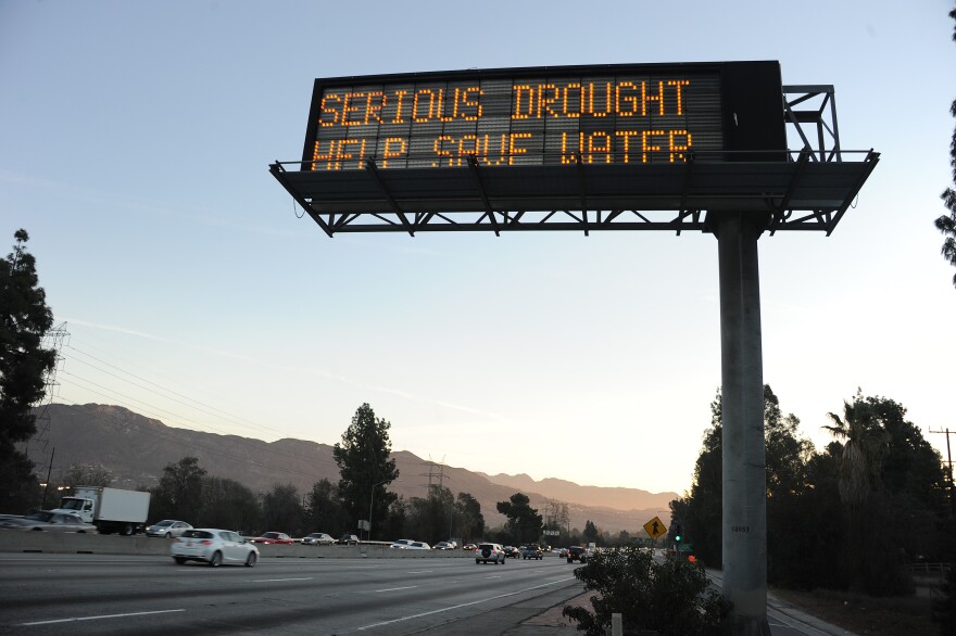 File: A sign over a highway in Glendale, California warns motorists to save water in response to the state's severe drought, Feb. 14, 2014.