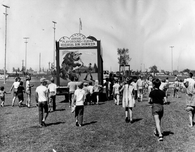 Children follow a truck as it drives into position at Granada Hills Playground to set up the 1964 Combined Traveling Circus and Kiddie Carnival. Photo dated: July 4, 1964. 