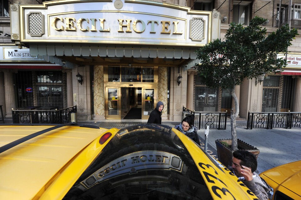A taxi driver waits as British tourists Mike and Sabina Baugh, both 27, leave the Cecil Hotel on February 20, 2013, after the body of 21-year-old Canadian tourist Elisa Lam was found in a water tank on the roof of the hotel.