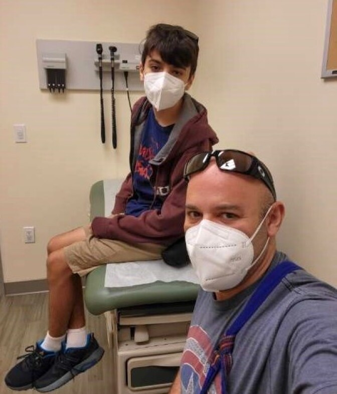 Robert and Lucas Garcia look at the camera while sitting in a patient room. 