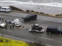 The Los Angeles Coroner is assisted by law enforcement officers to remove the body of a victim of a car crash where one person was killed and at least seven other people were injured, in a chain reaction, head-on crash in Malibu Calif. on Saturday Feb. 7, 2015. The SUV with a trailer is belong to Reality-TV star Bruce Jenner.