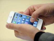A person looks at an iPhone 5 during the opening of a new Apple store on November 15, 2012 in Saint-Herblain, western France.