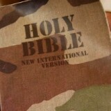 A US Army soldier displays his Bible with a camouflage cover after a Sunday evening Christian church service on a base in Baghdad. 