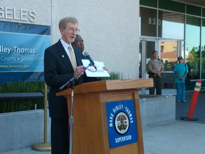 Director of the Department of Children and Family Services Phillip Browning holds up a sign with the Child Protection Hotline, 800-540-4000. 