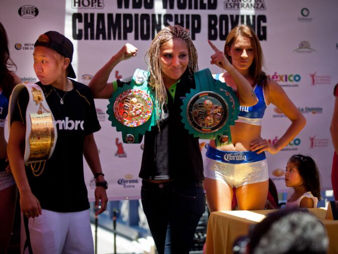 The countdown has begun for Saturday's match between World Boxing Champion Mariana "Barbie" Juarez (right, with fist raised) and her challenger Champion of the Asian-Pacific, Japanese boxer Shindo Go (left), at a Lunch-Press Conference, Monday July 9, at "Plaza de la Cultura."  The ten-round fight, to be held on Saturday July 14th, will benefit the "Mundo Maya Foundation", whose leader Sara Mijares, says that she’s, "Very excited to have the support of the Boxing Champion Mariana "Barbie" Juarez to support us as migrant women."