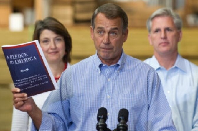 US House Minority Leader John Boehner of Ohio (C), holds up a copy of the Republican's new governing agenda, known as 'A Pledge to America,' for the 111th Congress at Tart Lumber Company in Sterling, Virginia, September 23, 2010.