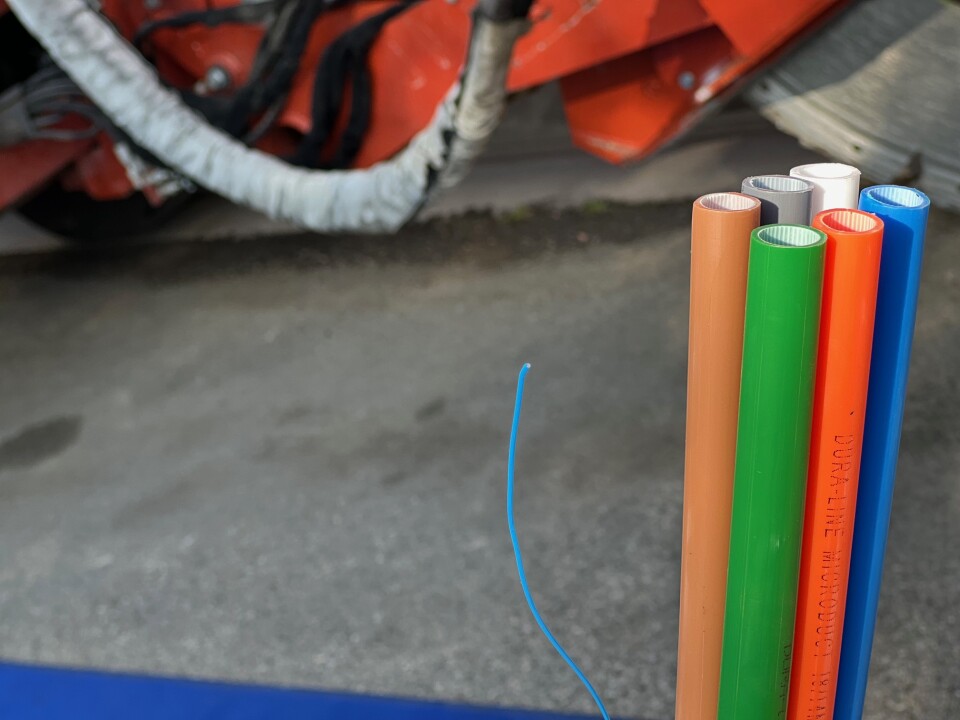 A closeup of a bunch of brightly colored (orange, green, red, grey, white and blue) cables that will be used to connect homes and businesses to the internet.