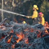 MALIBU, CA - NOVEMBER 11: Firefighters battle a blaze at the Salvation Army Camp on November 10, 2018 in Malibu, California. The Woolsey fire has burned over 70,000 acres and has reached the Pacific Coast at Malibu as it continues grow.  (Photo by Sandy Huffaker/Getty Images)