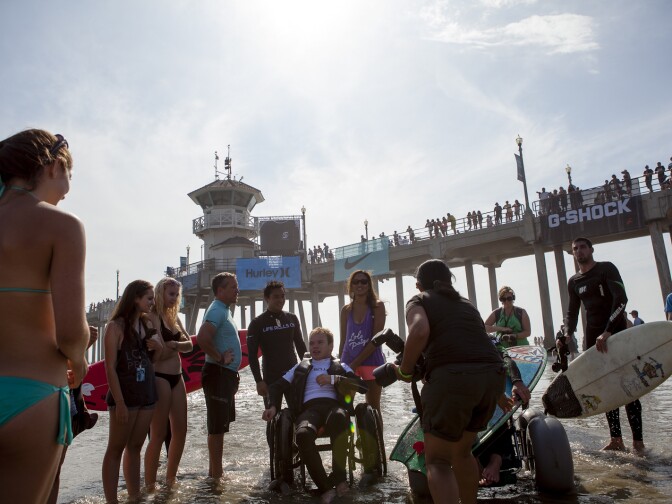 Life Rolls On ambassador, Patrick Ivison, is surrounded by friends and family after his turn in the water at the 2012 US Open of Surfing.